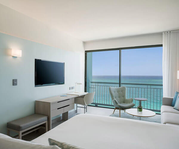 Guest room with a king bed, a balcony, and an ocean view