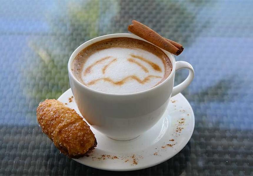 A cup of coffee with some pastry