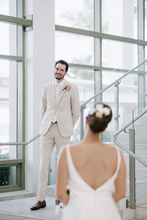 The groom on staircase looking at bride