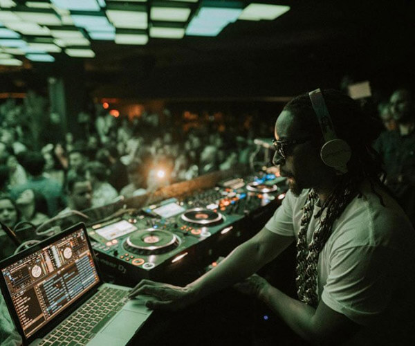 DJ playing for a packed room of people dancing