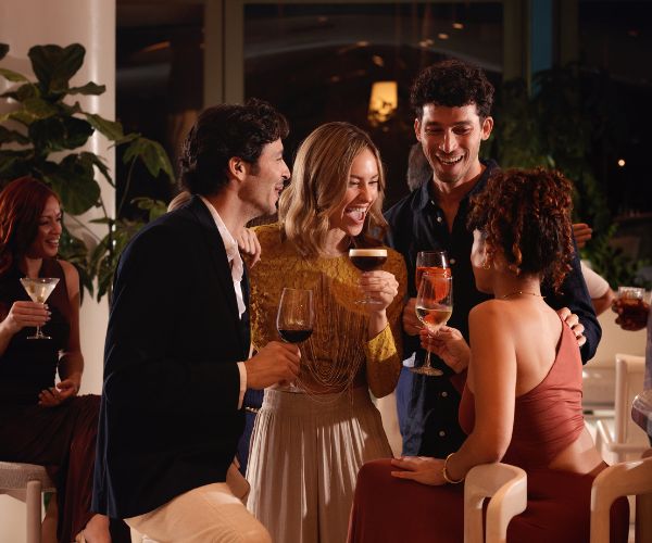 Groups of friends socializing in the Lobby in semi-formal attire with drinks