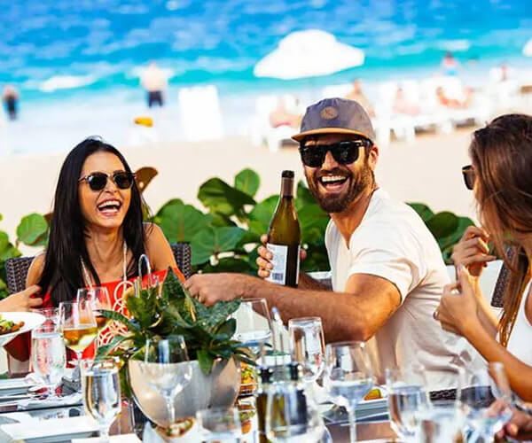 Group of friends in sunglasses enjoying wine and entrées