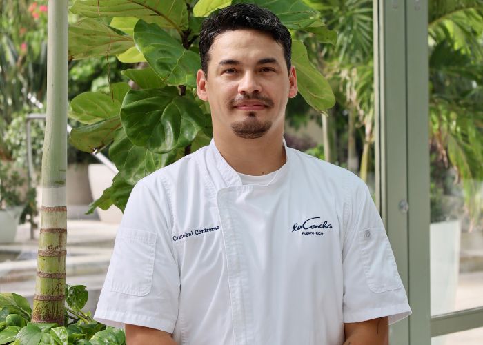 Chef Contreras standing in front of palm trees at La Concha Resort