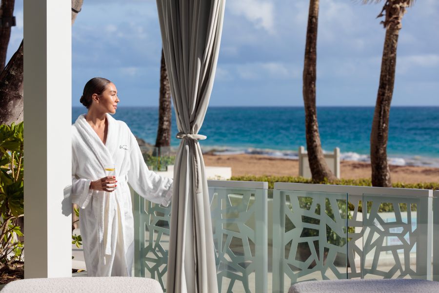 Lady in Spa robe in spa terrace looking at the beach