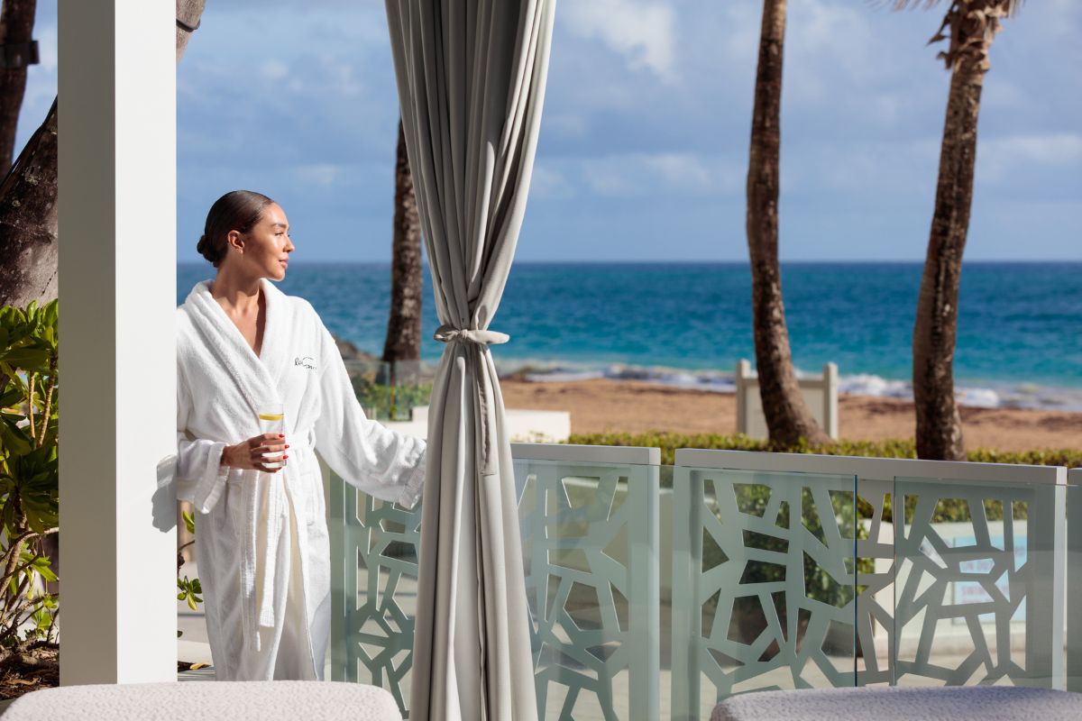 Lady in Spa robe in spa terrace looking at the beach