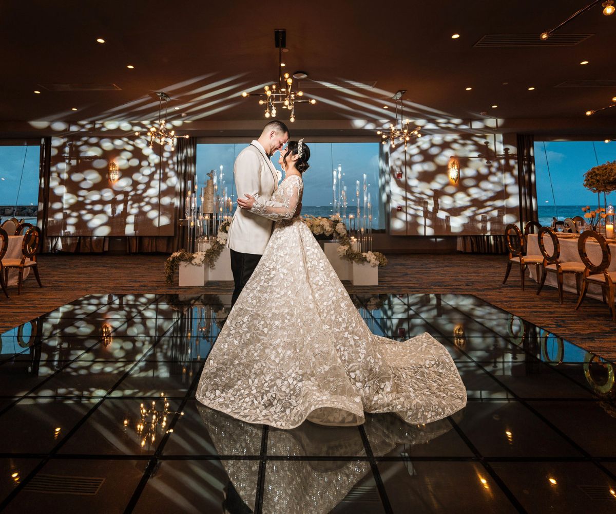 Banquet setup with clear-backed chairs and white floral arrangements