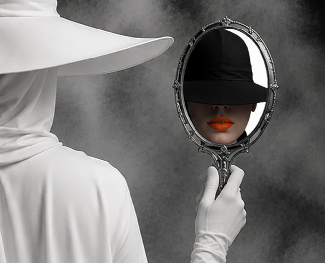 person in white looking on a hand mirror and reflection looks back wearing black