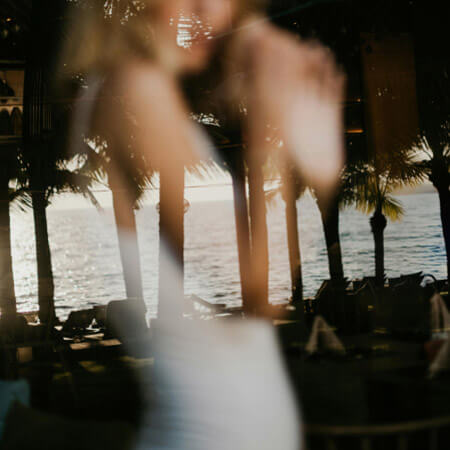 Palm trees along the beach with a faded and blurred bride layered on top