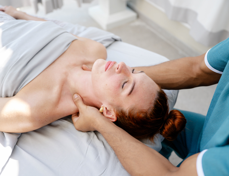 woman with gray towel enjoying neck massage at elemara spa