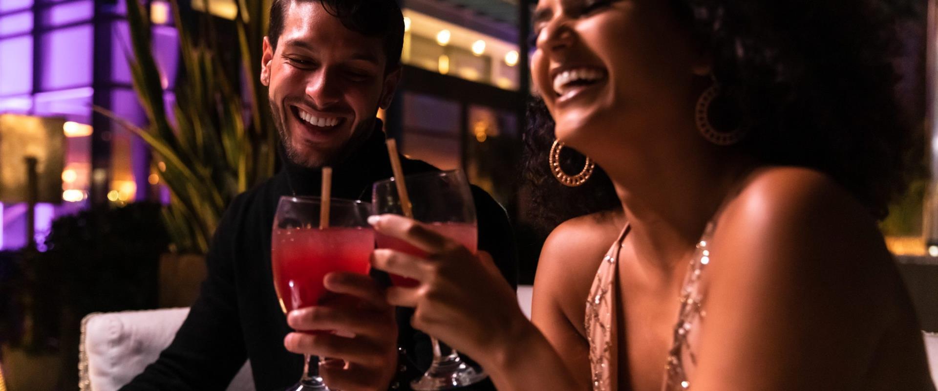 Two people drinking alcohol and smiling