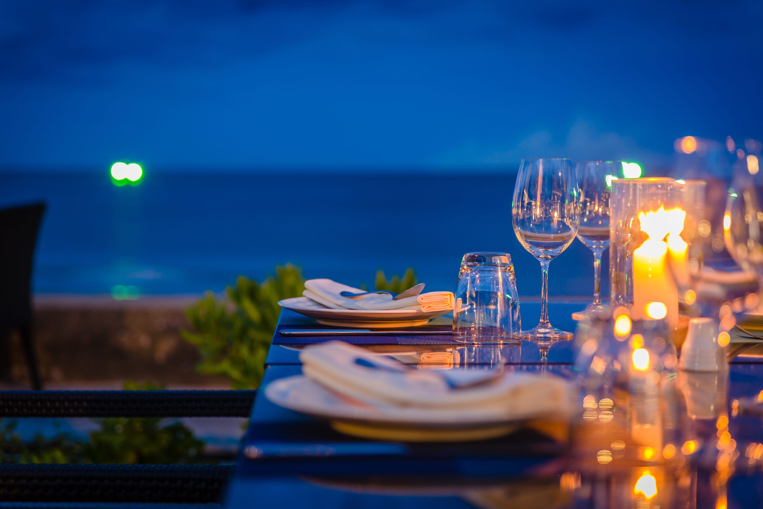 Beachside dinner table with plates and glasses